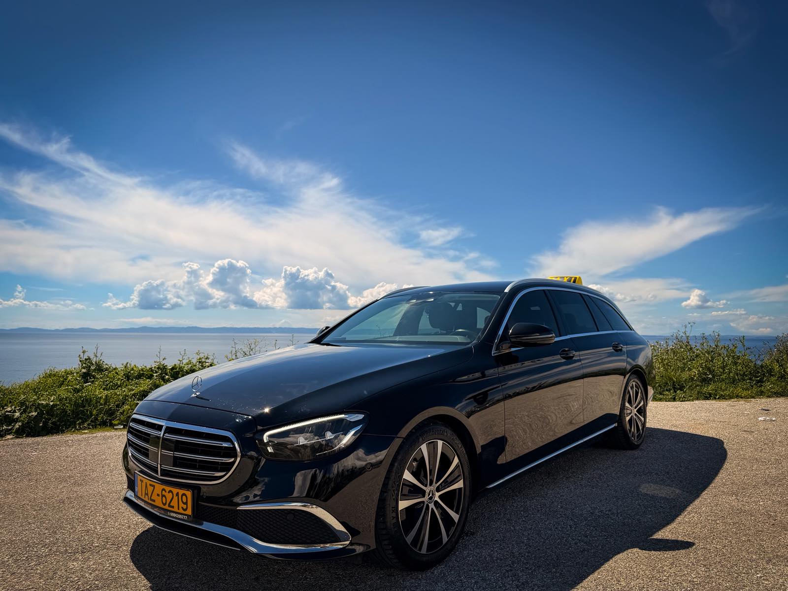 Eagle Taxi black Mercedes E220 parked above the sea in Nikiti, Halkidiki