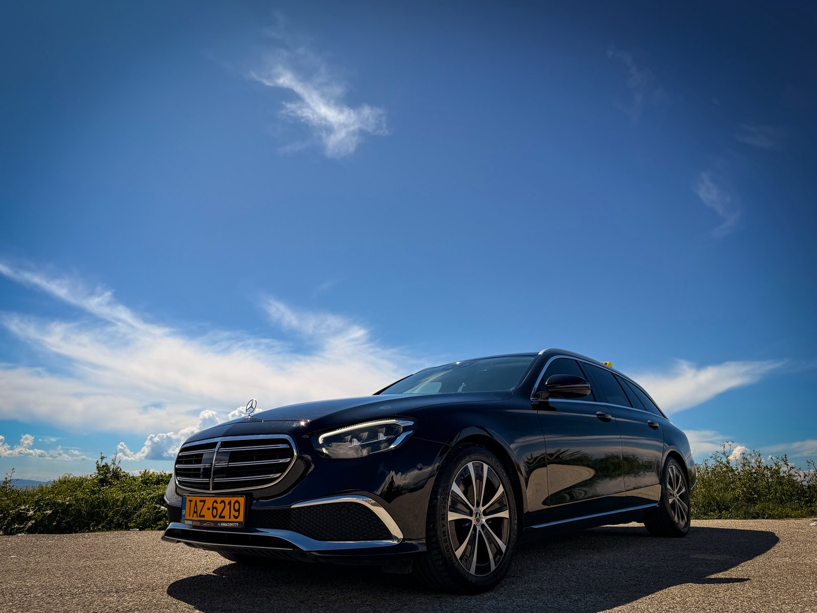 Black Mercedes E220 taxi under a clear blue Halkidiki sky